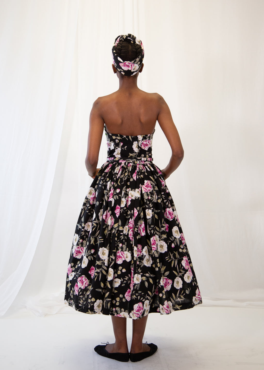 Woman wearing a black floral dress with a white background