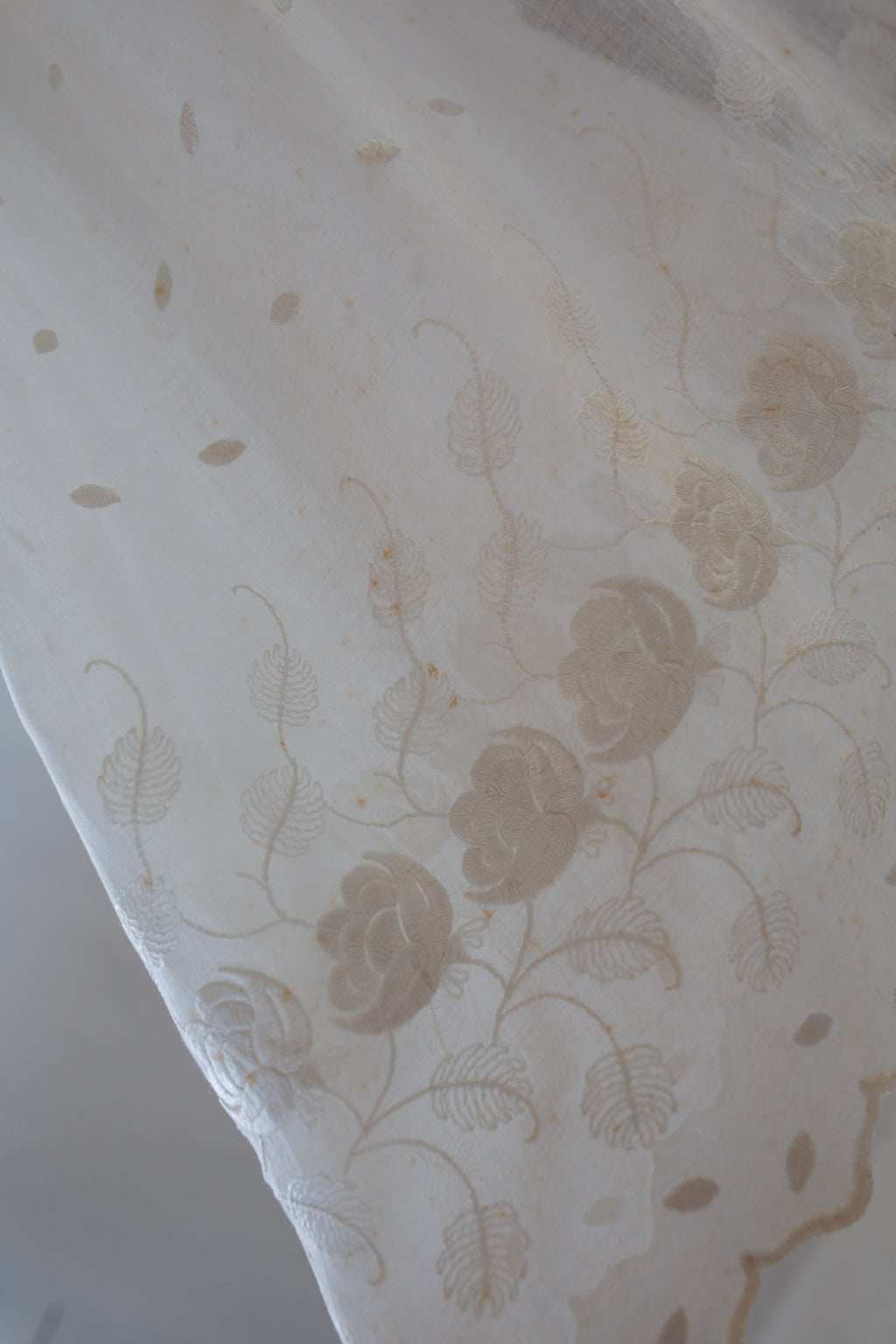 Close-up of a textured fabric with floral pattern on a light background