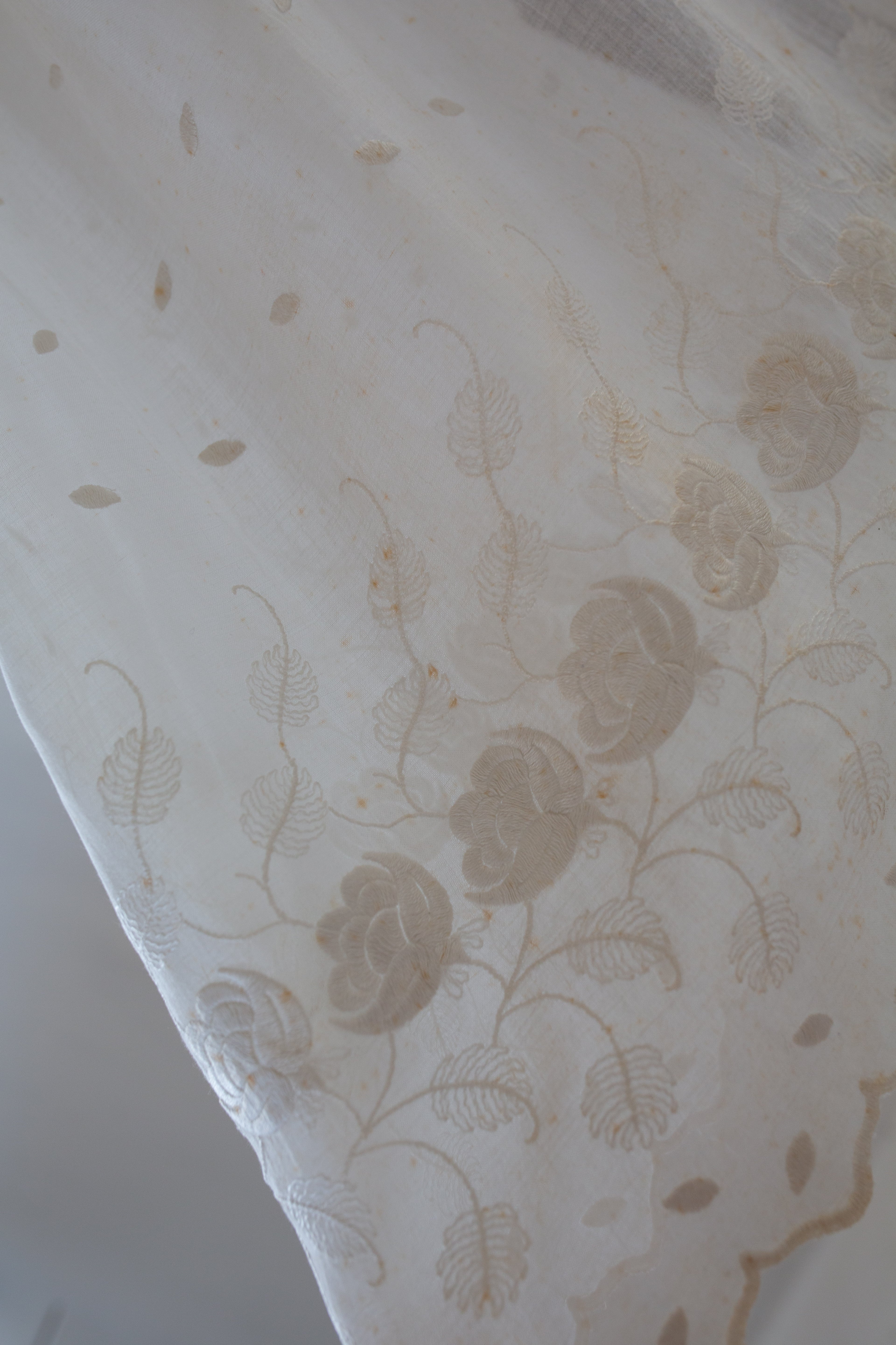 Close-up of a textured fabric with floral pattern on a light background