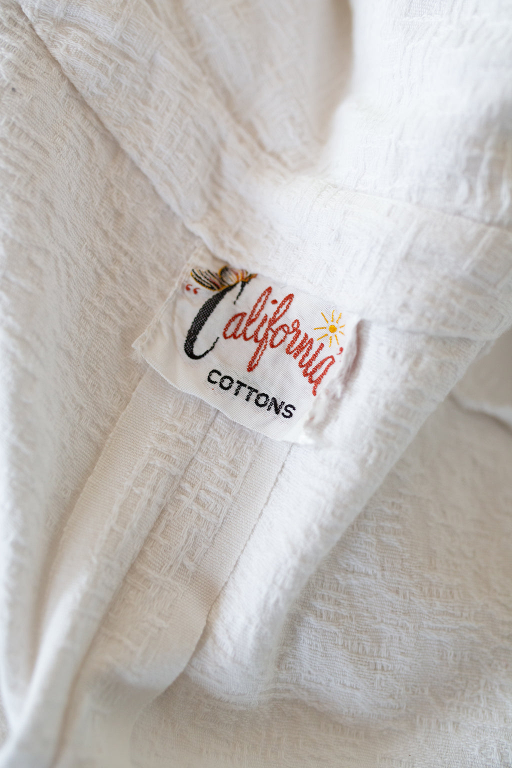 Close-up of a white fabric with 'California Cottons' label.