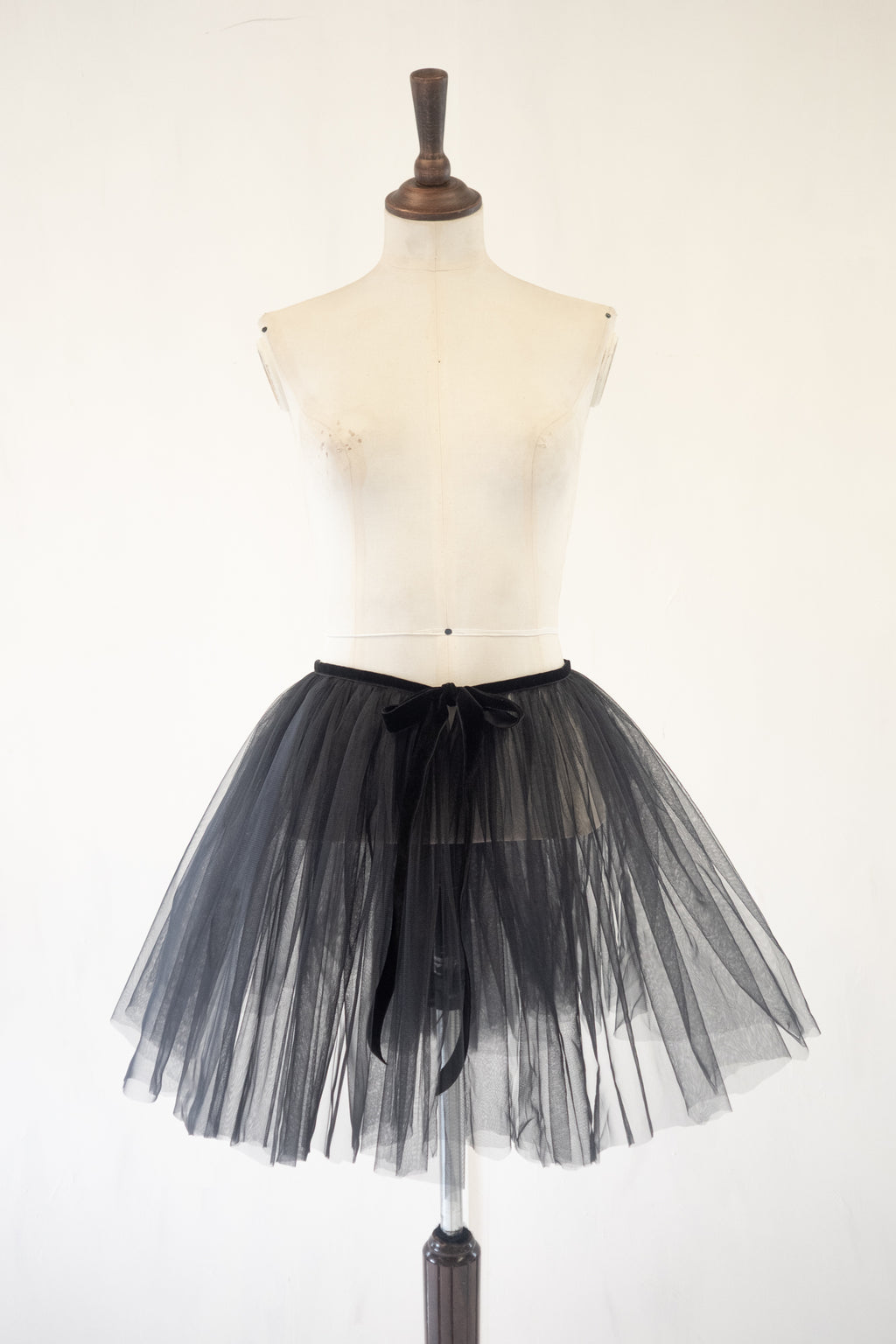 Black tulle skirt on a mannequin against a white background