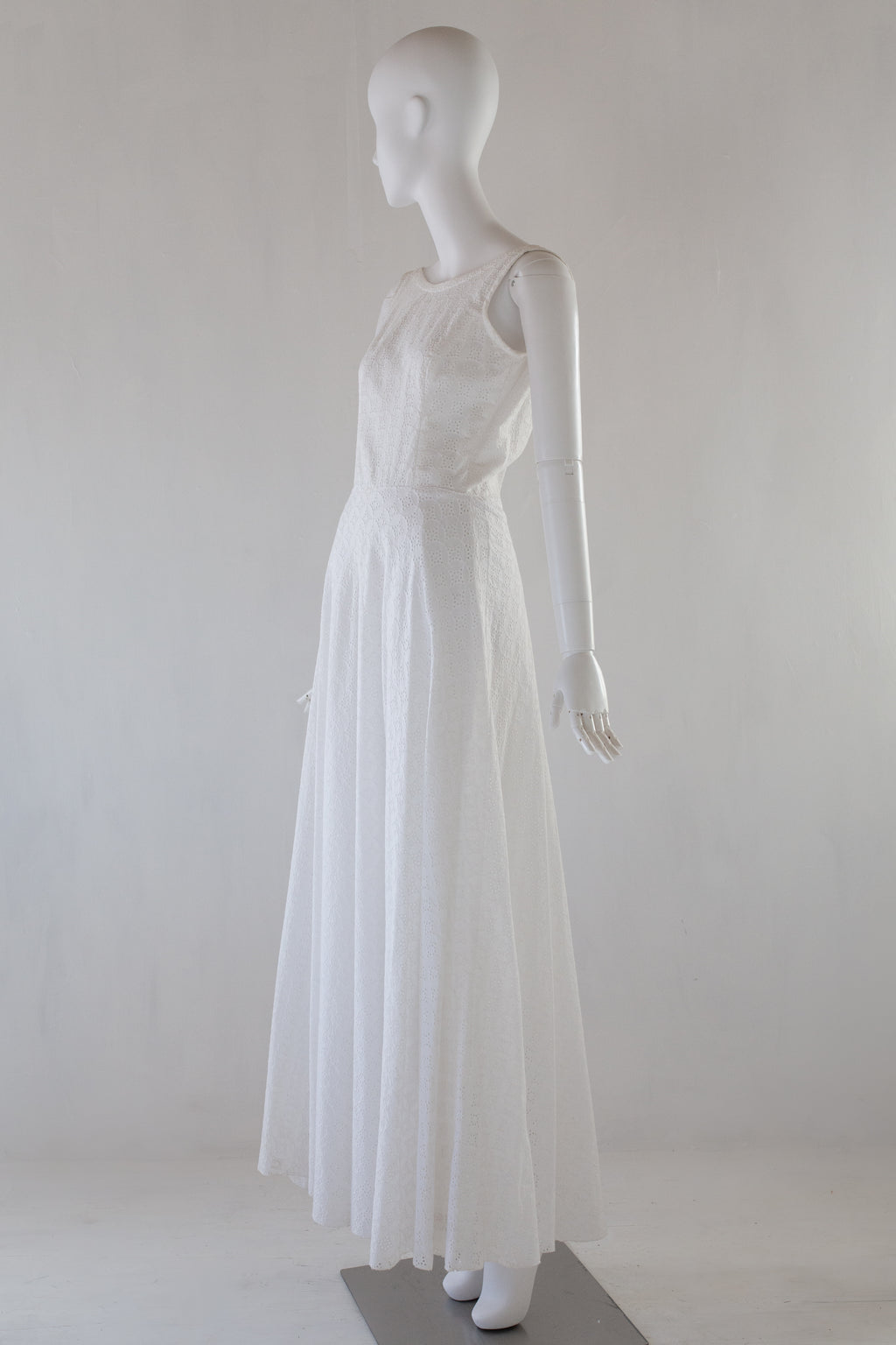 White broiderie anglaise dress on a mannequin against a white background