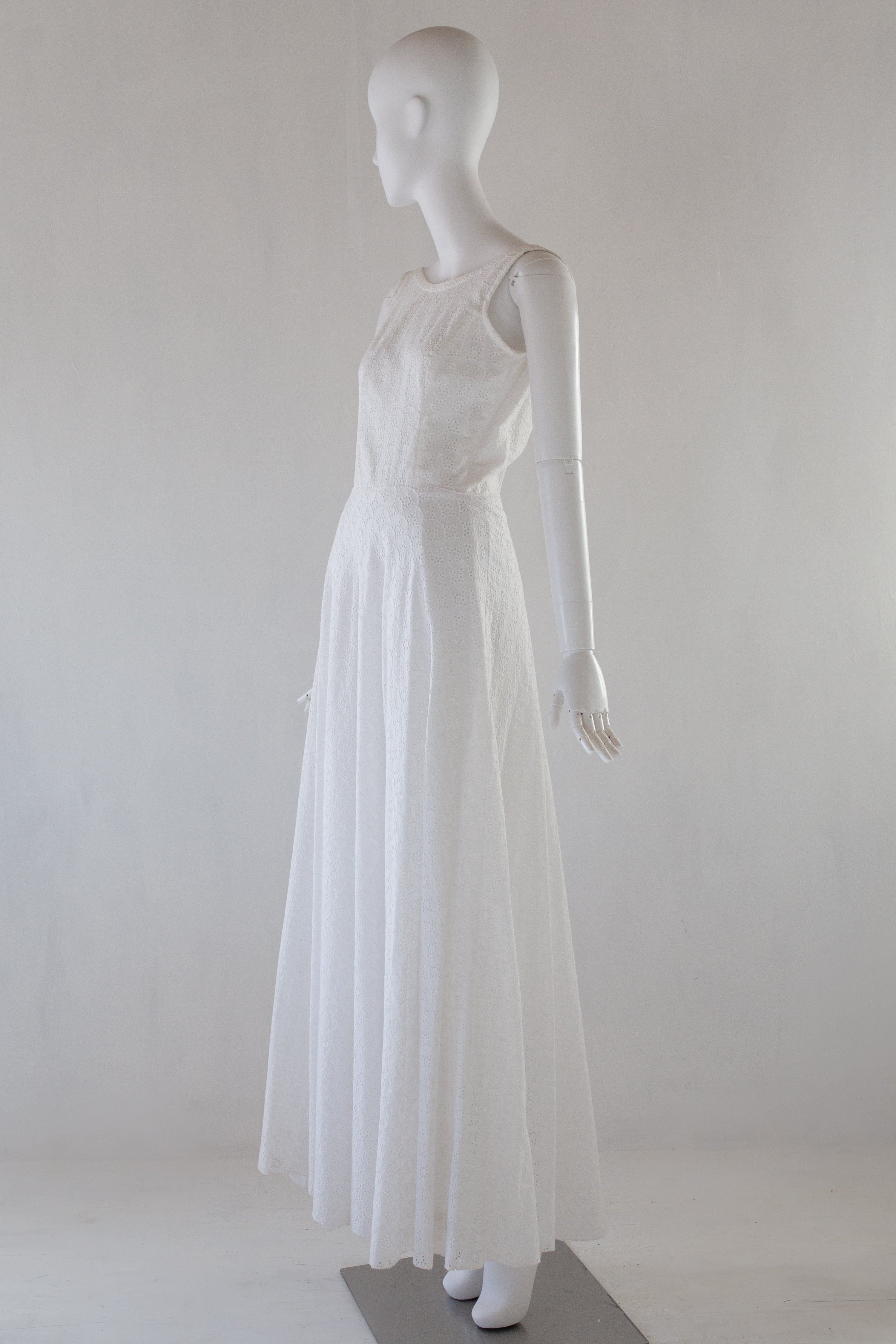 White broiderie anglaise dress on a mannequin against a white background