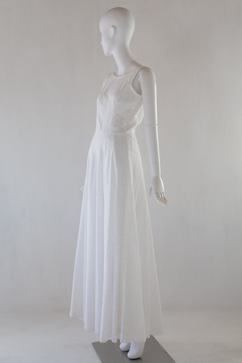 White broiderie anglaise dress on a mannequin against a white background