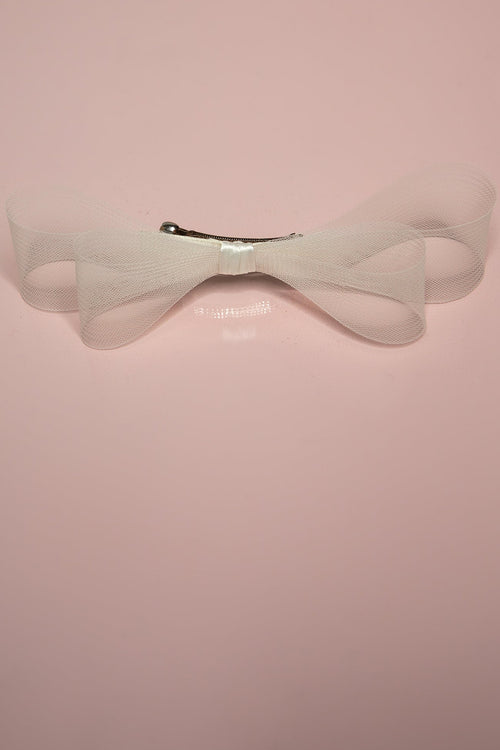 A double hair bow with a cream-colored crinoline and satin center, mounted on a barrette clip, displayed against a pink background.
