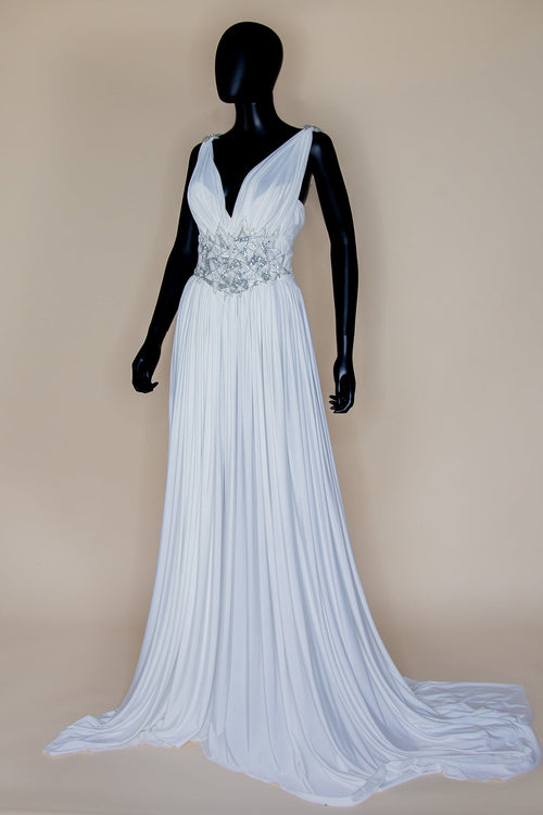 A white draped jersey hand-beaded star gown with silver art deco stars, displayed on a mannequin by Alexandra King bridal.