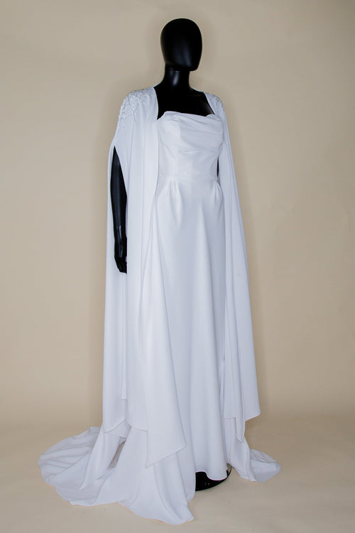 An old hollywood style wedding dress in light ivory crepe with a cape, featuring a sweetheart bodice and a flared skirt.