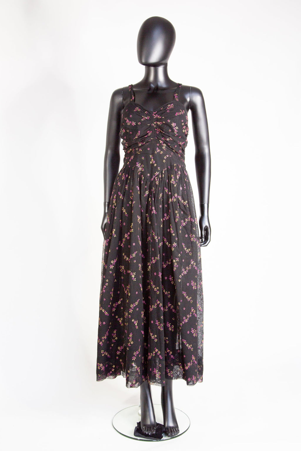 Vintage 1940s black printed tulle maxi dress with a sweetheart ruched bodice and floral print, displayed on a mannequin.