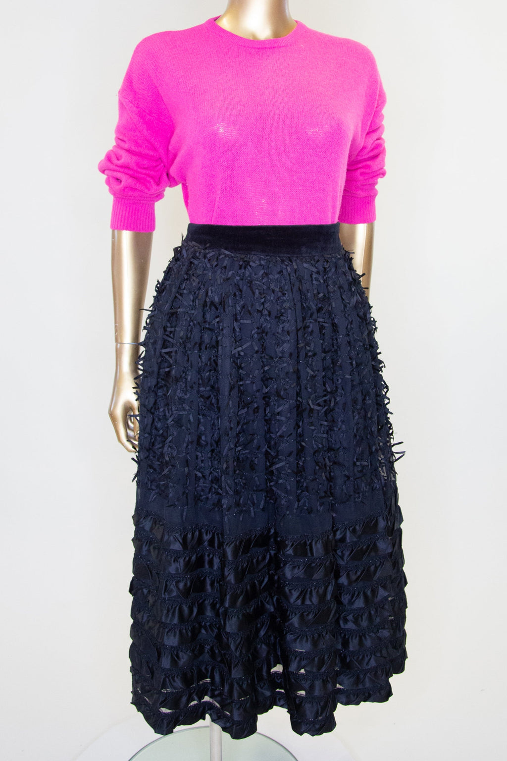 Vintage 1980s black satin ribbon work midi skirt on a mannequin, featuring a fitted waist and a flared skirt with ribbon embellishments and a stripe hem.
