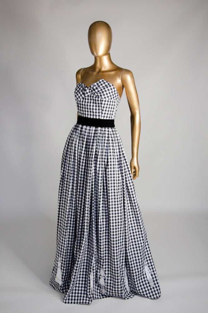 Black and white gingham cotton ballgown dress with applique people hem, displayed on a mannequin.
