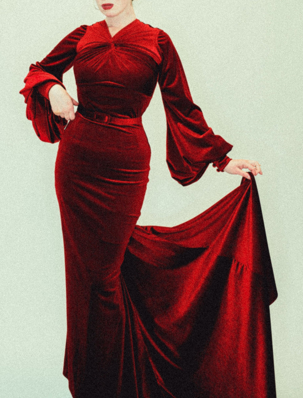 Woman wearing a 1930s old hollywood red velvet dress against a light background by Alexandra King