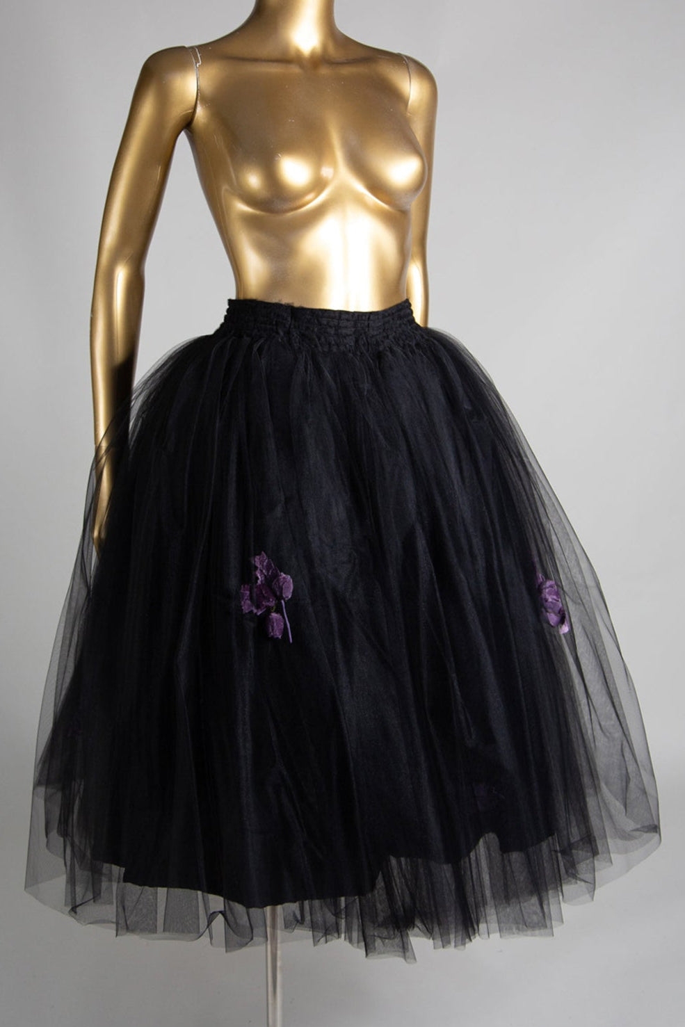 Black tulle skirt with purple velvet rose corsages, displayed on a mannequin with a smocked waistband and double popper fastening.